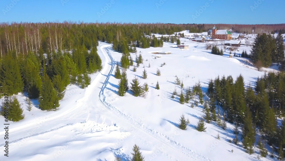 Top view of beautiful winter landscapes with forest. Clip. Beautiful green forest with snowy roads and frozen rivers. Winter forest in sunny weather