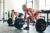 Levelling up on their fitness game. Shot of two sporty young woman lifting weights at the gym.