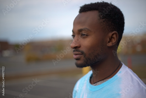 thoughtful young man wearing t-shirt outside in the parking lot