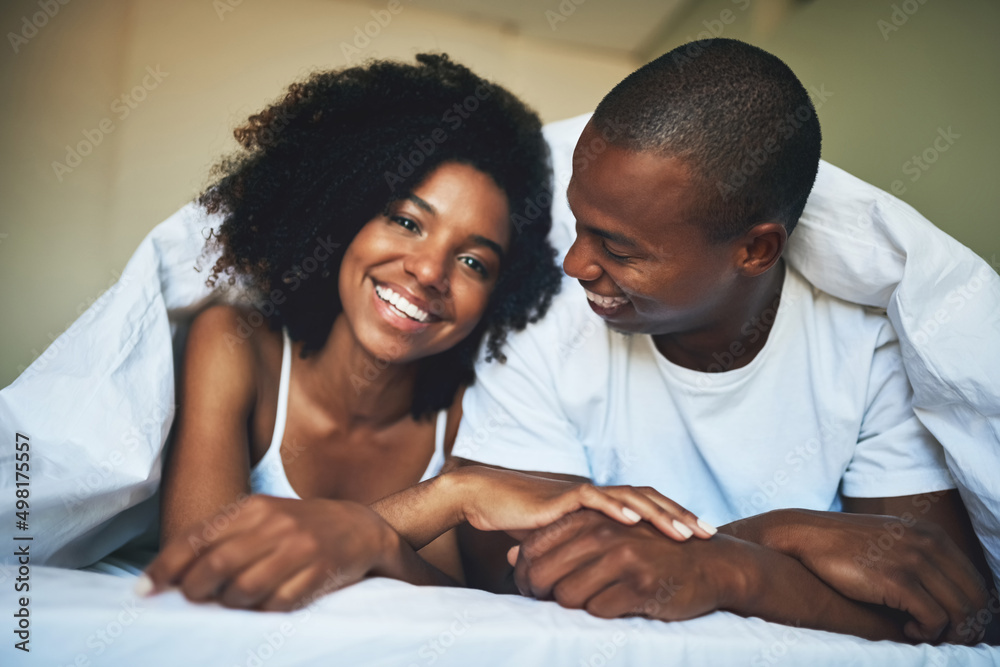 Obraz premium Its hard not to be happy waking up to love. Portrait of a happy young couple relaxing under a duvet in their bedroom.