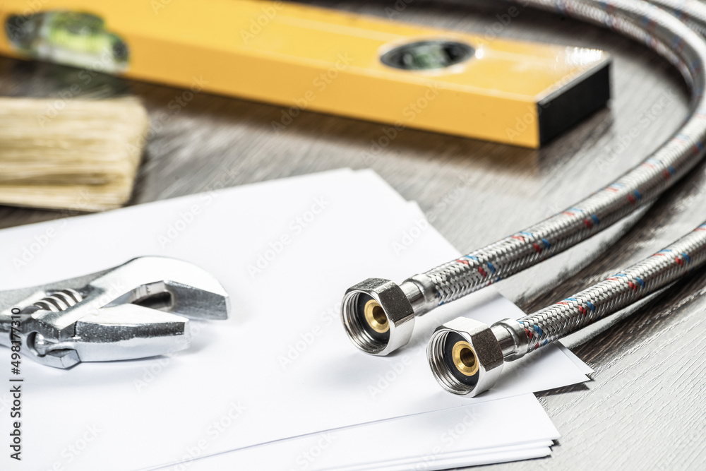 Flexible steel water hoses laying on table