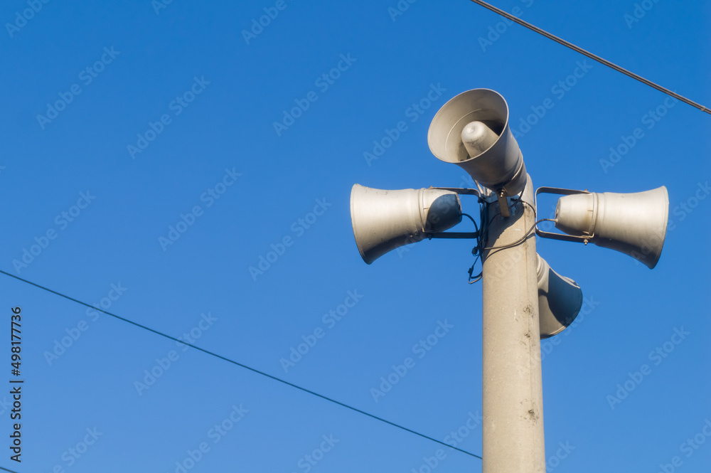 Public address system on the pole. Loudspeakers alerting the public about incidents and giving alarm signals. Outdoor PA speakers. Selective focus Public address system on the pole. Loudspeakers alerting the public about incidents and giving alarm signals. Outdoor PA speakers. Selective focus