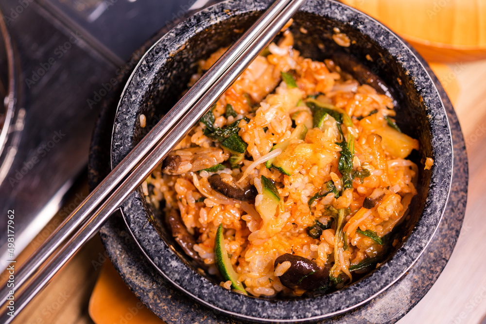 Bibimbap in a black heated stone bowl, Korean traditional dish- bibimbap mixed rice with vegetables Include beef and fried egg, Japanese hot pot food Bibimbap in a black heated stone bowl, Korean traditional dish- bibimbap mixed rice with vegetables Include beef and fried egg, Japanese hot pot food
