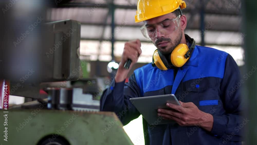 Professional maintenance engineer, technician worker, repairman wear uniform, safety hard hat using tablet computer checking control machine in factory. Manufacturing heavy machine Industry concept. Professional maintenance engineer, technician worker, repairman wear uniform, safety hard hat using tablet computer checking control machine in factory. Manufacturing heavy machine Industry concept.