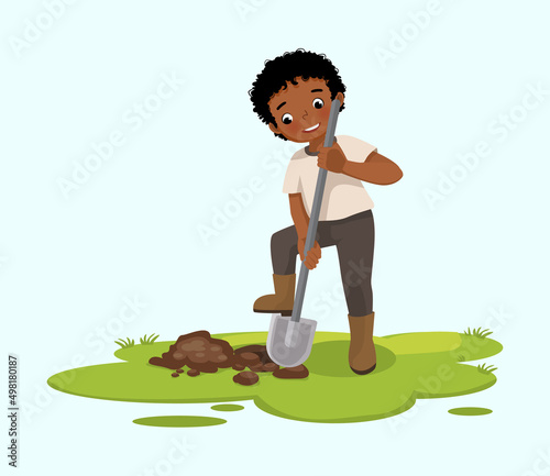 Cute little African boy digging hole on the ground with shovel in the garden