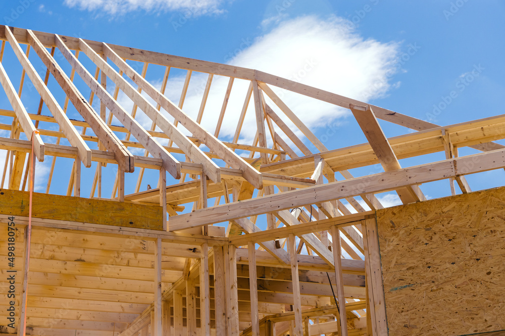 Obraz premium Panoramic view of wooden frame house under construction, roof beams