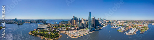 Panoramic wide aerial drone view of Sydney City spanning from North Sydney to Pyrmont showing the Sydney Harbour Bridge and Sydney Harbour on a sunny day  