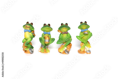 A group of four green ceramic frog figurines