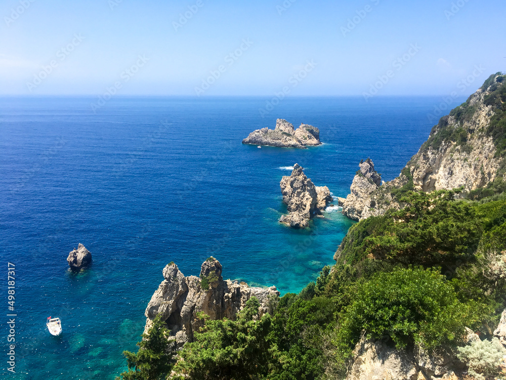 Corfu, Greece - July 9, 2018: Beautiful view of the bay with azure water of the Ionian Sea in Paleokastritsa area. Rocks peek out of the water creating an unusual landscape