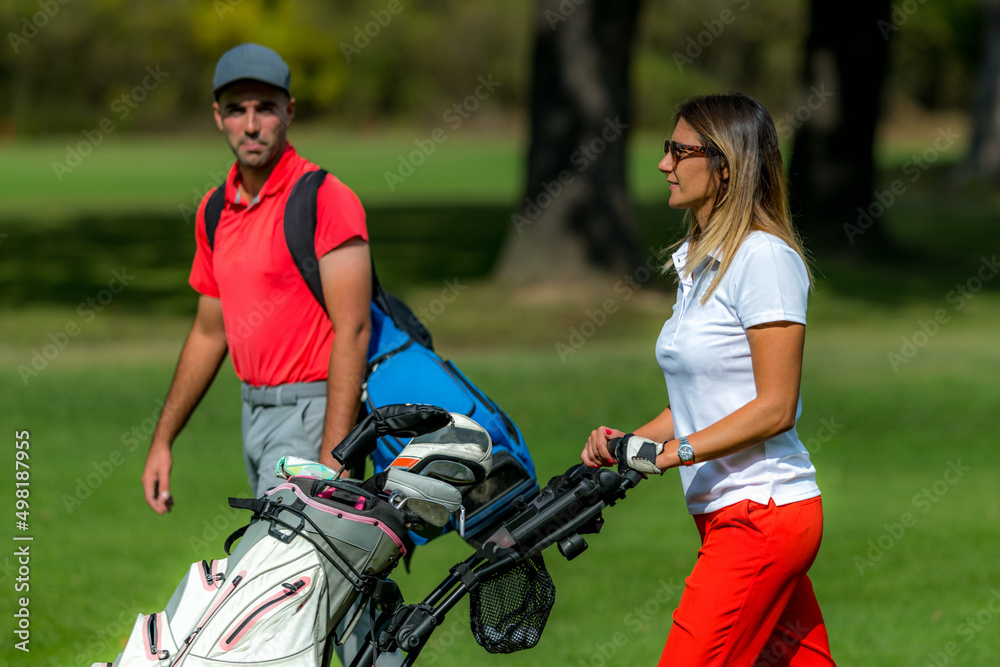 Fototapeta premium Golfing couple enjoying a game on a golf course