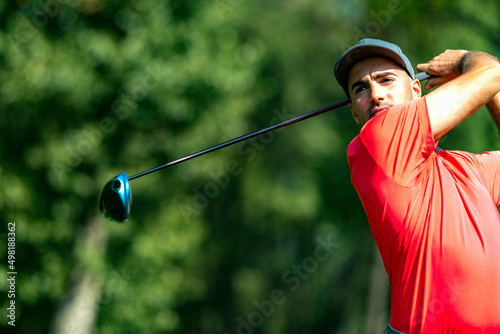 Professional golfer in a swing using a driver golf club photo