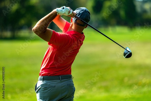 Professional golfer in a swing using a driver golf club, rear view photo