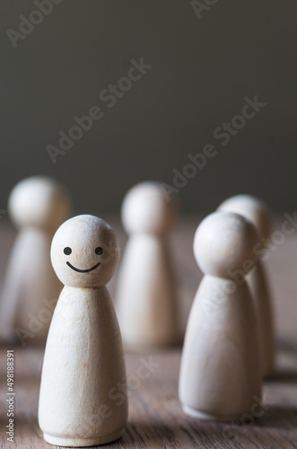 Close up standing wooden dolls, row of human represent figure on the table, blurred and select focus