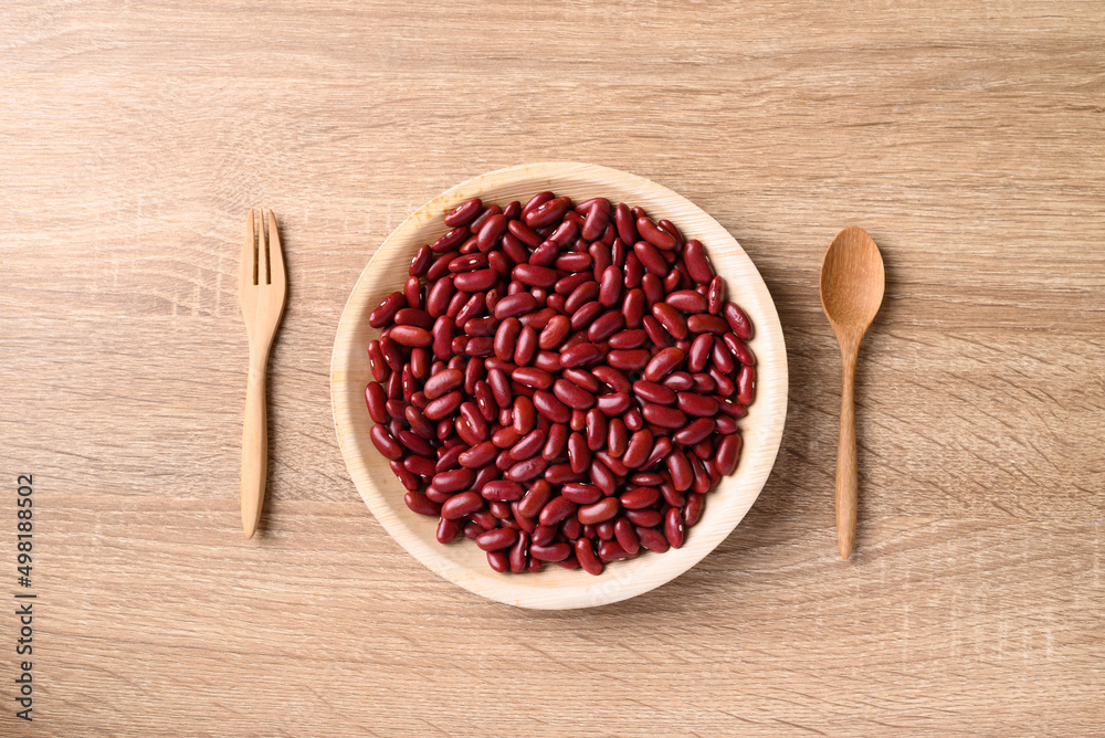 Red kidney bean on plate with spoon and fork on wooden background, Table top view Red kidney bean on plate with spoon and fork on wooden background, Table top view