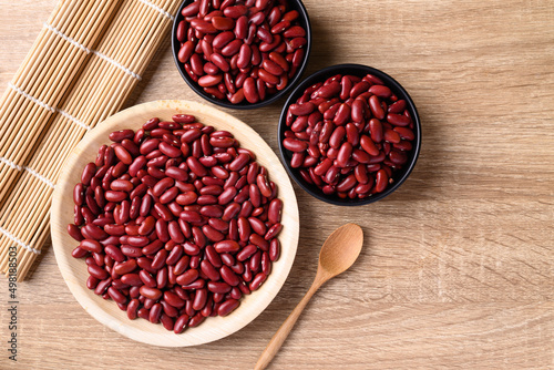 Foto Red kidney bean on plate and bowl with spoon on wooden background, Table top vie
