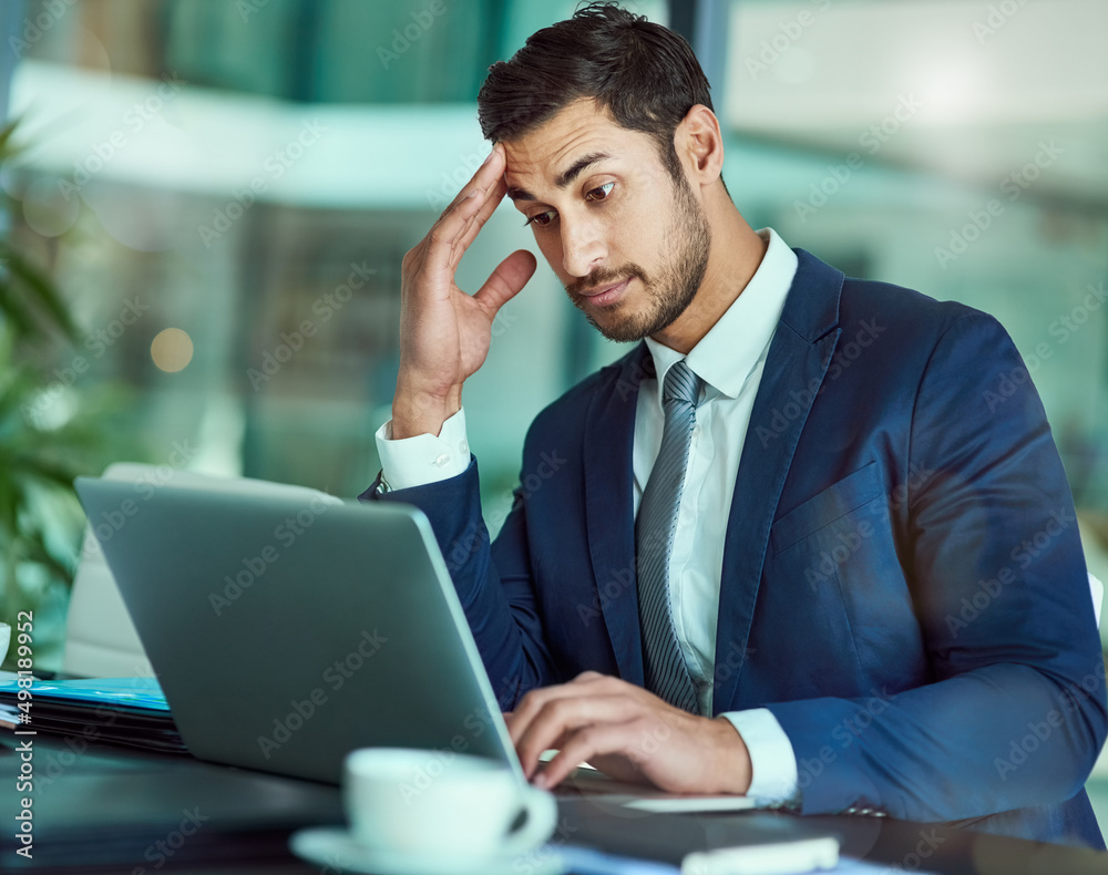 This isnt good.... Shot of an stressed executive working on a laptop in an office. This isnt good.... Shot of an stressed executive working on a laptop in an office.