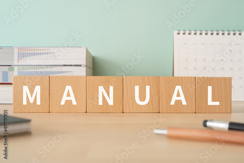 Foto マニュアルのイメージ「MANUAL」と書かれた積み木が置かれたデスク