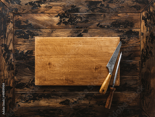 Canvas Print Vintage bayonet knife and meat cleaver on wooden cutting board
