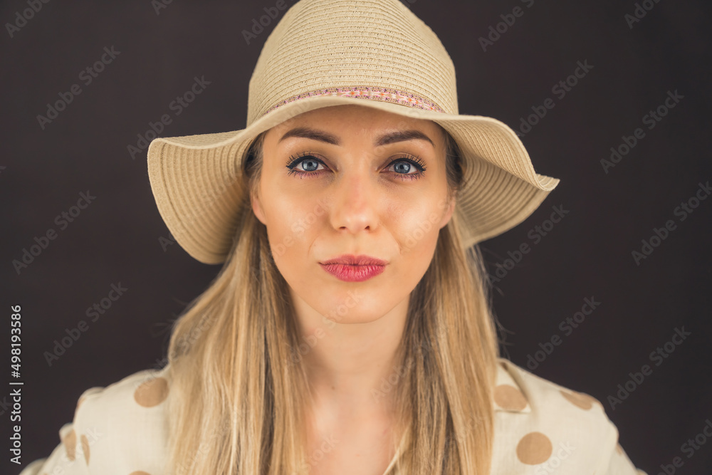 portrait of a blonde European girl with blue eyes wearing a hat closeup studio shot grey background . High quality photo portrait of a blonde European girl with blue eyes wearing a hat closeup studio shot grey background . High quality photo