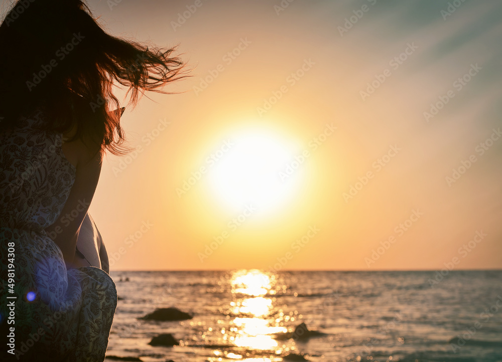 woman on sea shore at sunset