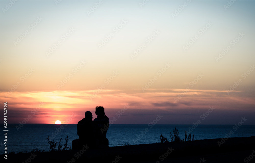 couple on sea shore at sunset