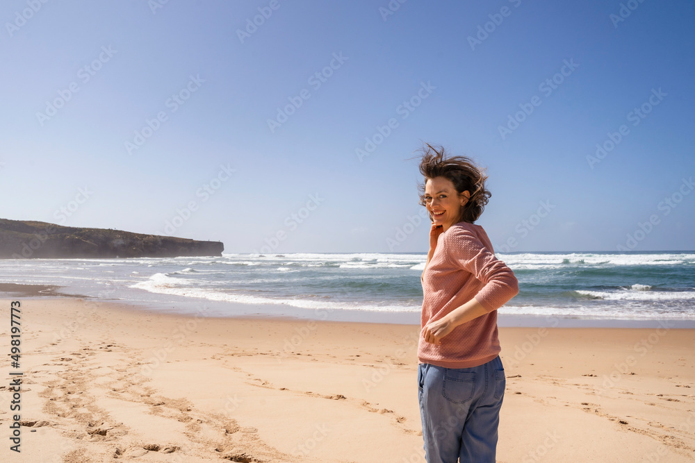 Happy woman running towards sea at beach on sunny day Happy woman running towards sea at beach on sunny day