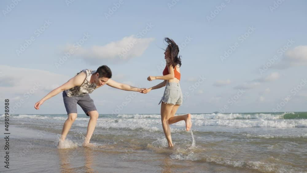 Asian young man and woman having fun, playing on the beach together. Asian young man and woman having fun, playing on the beach together.