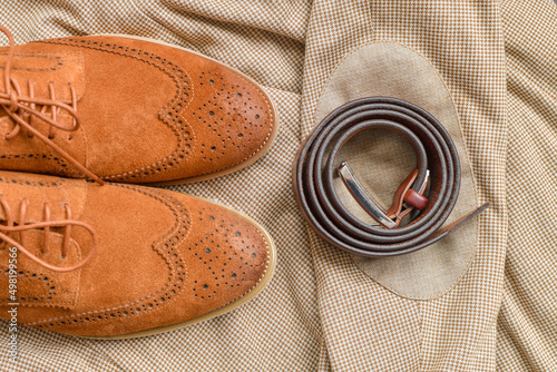 Men brown suede brogue shoes combined with light beige blazer and belt. Top view. photo