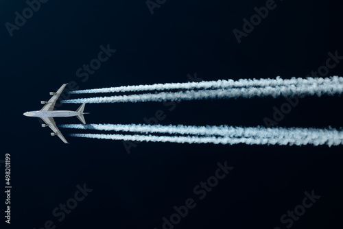 Airliner mit Kondensstreifen vor blauem Himmel