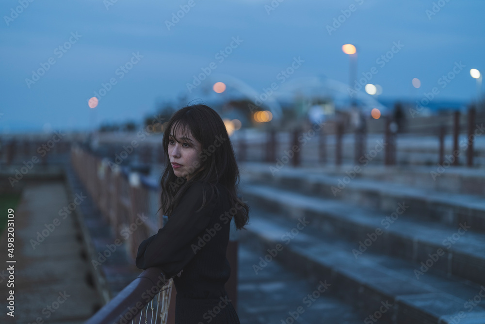 夕暮れの海沿いで散策する女性 夕暮れの海沿いで散策する女性