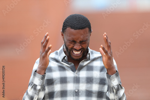 Stressed man with black skin complaining in the street Fototapet