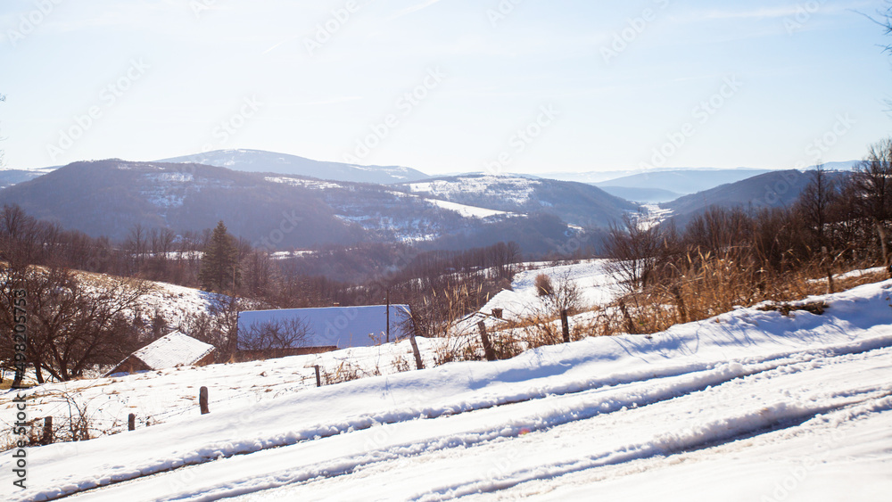 Countryside Winters Scenery. Winter Nature Landscape. Snow Covered Rural Road. Pastoral Country Terrain. Blue Sky. Hills And Fields.