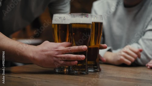 Close up of unrecognizable man bringing beer glasses for friends. Shot with RED helium camera in 8K. 