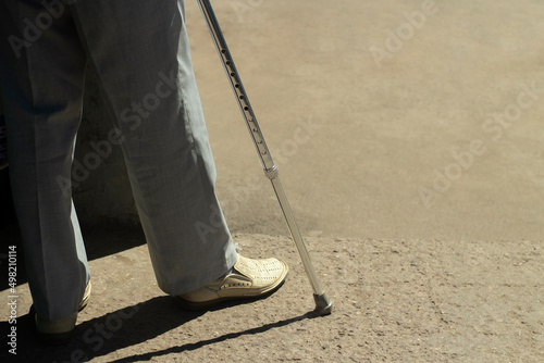 Walking stick. A man with a leg injury.