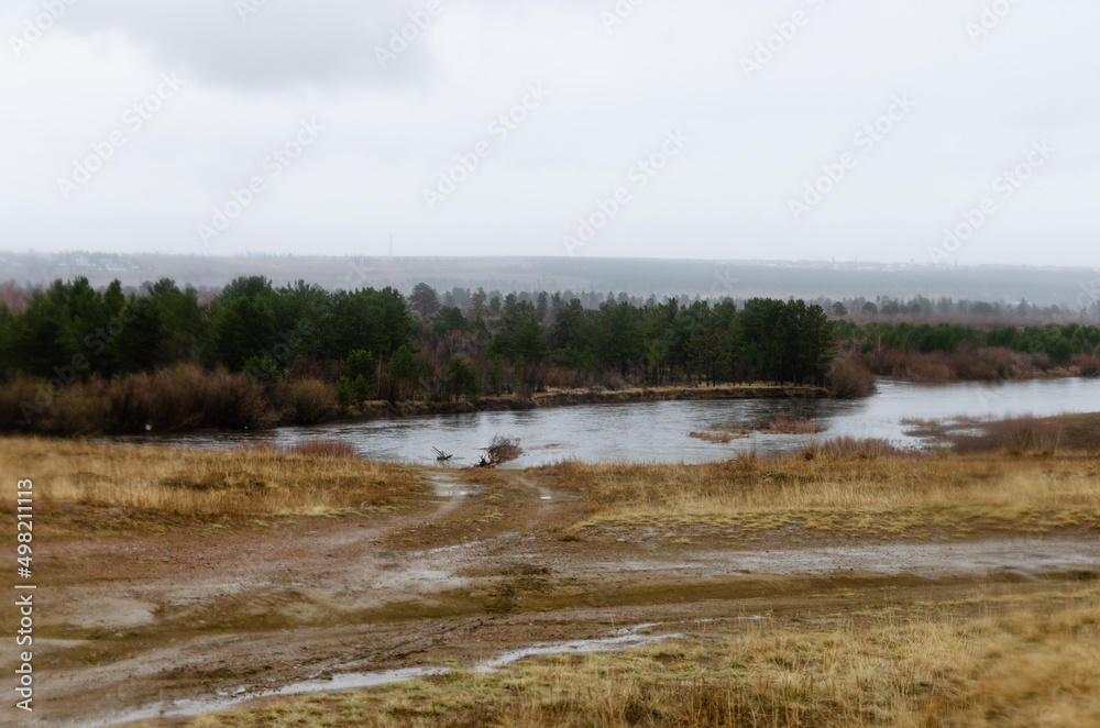 Rainy weather. A washed-out dirt road near the river.