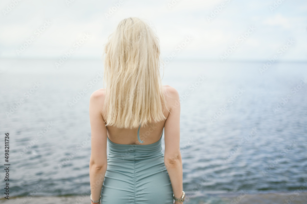 Woman in blue dress enjoys a walking near the sea shore. Woman in blue dress enjoys a walking near the sea shore.