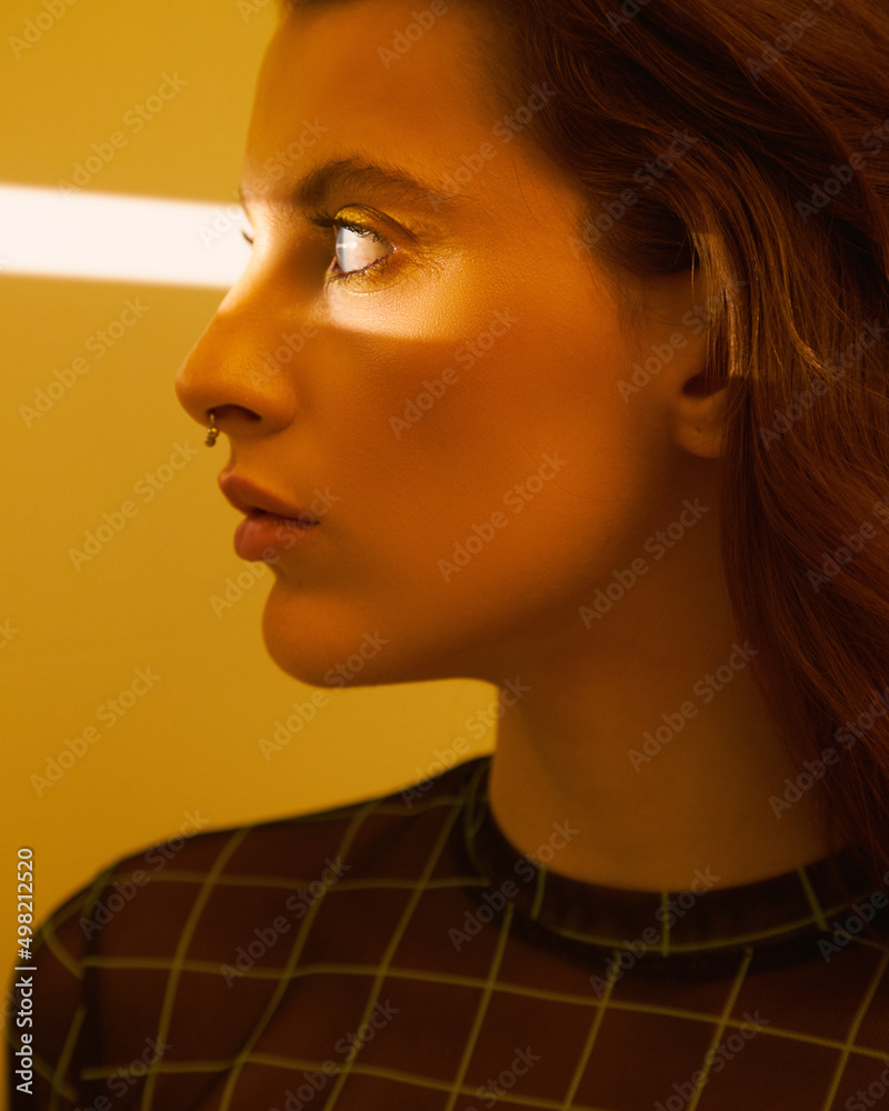 Fashion photoshoot of a young girl in yellow creative light. Vogue