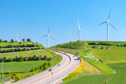 Paysage du pays de Bray traversé par l'autoroute A28. Parc éolien en arrière-plan. Champs de blé et paturages