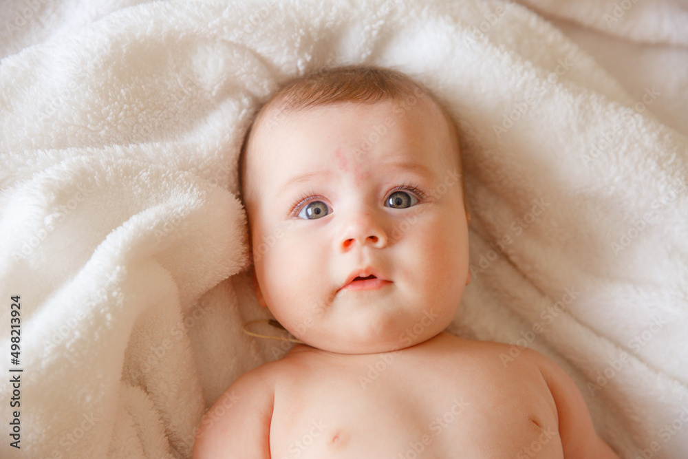 baby is wearing diapers and a white towel in bedroom. A newborn baby is resting in bed after a bath or shower. Children's room. Textiles and bedding for children. baby is wearing diapers and a white towel in bedroom. A newborn baby is resting in bed after a bath or shower. Children's room. Textiles and bedding for children.