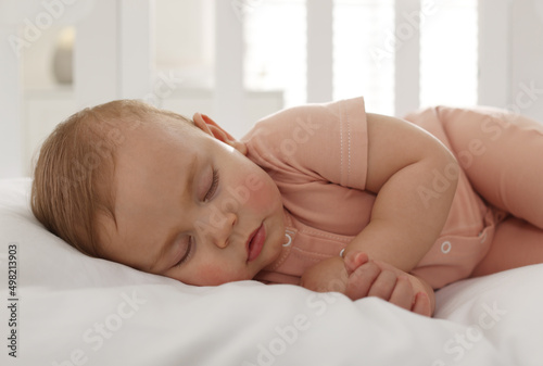 Cute little baby sleeping in soft crib, closeup