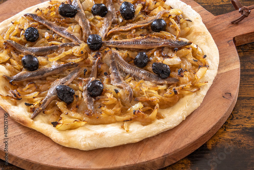 pissaladière cooked on a wooden board on a table