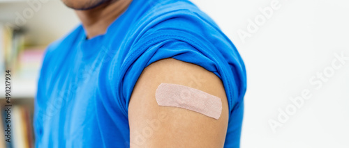 Arm of man with plaster after vaccination