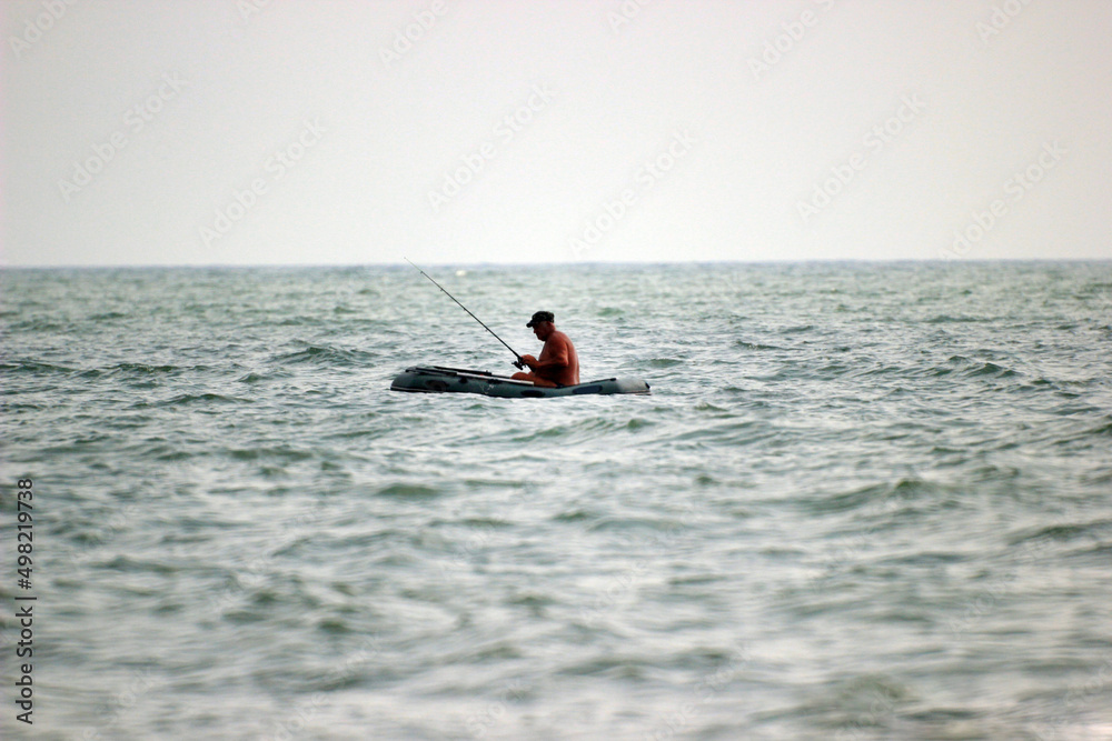 fisherman catches fish in the Black sea on a boat
