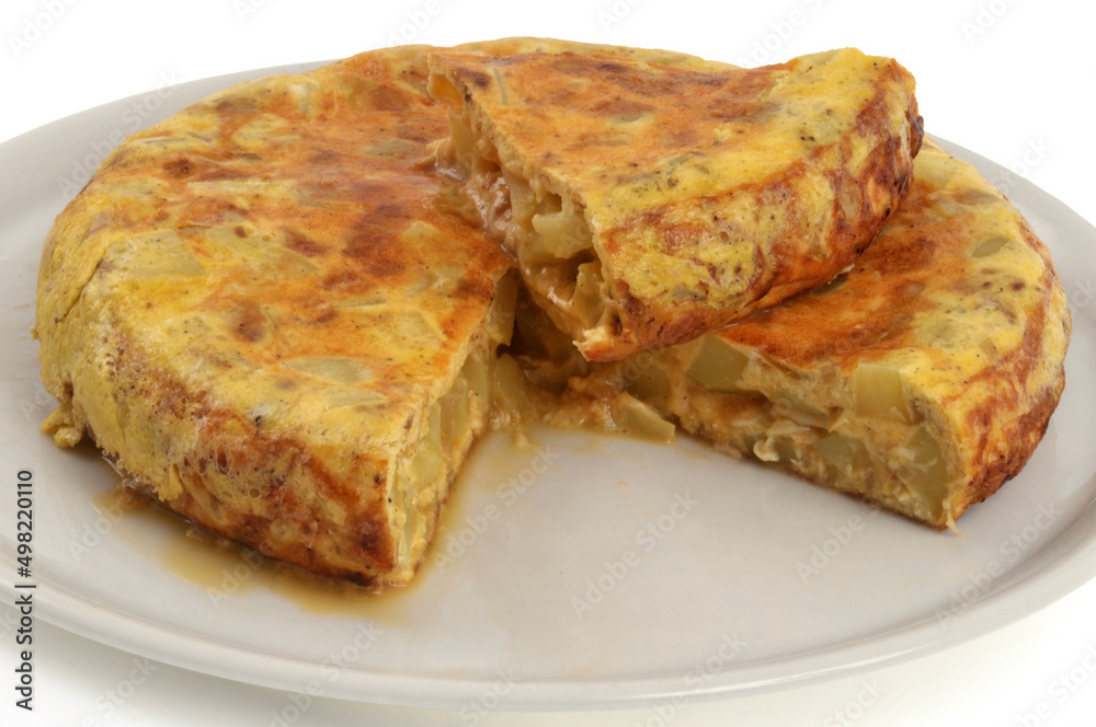 Omelette espagnole dans une assiette avec une part coupée vue de dessus en gros plan Omelette espagnole dans une assiette avec une part coupée vue de dessus en gros plan