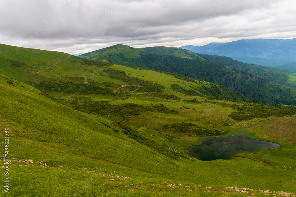 Mountain lake in the Carpathians, against the background of the sky and clouds. summer landscape