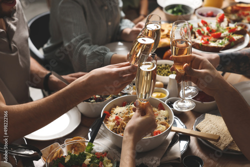 Group of people clinking glasses with champagne during brunch at table, closeup