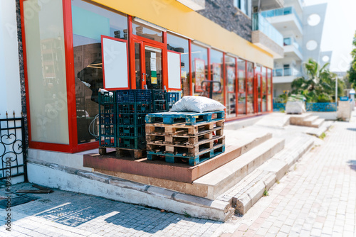 Empty pallets outside the store. Wooden pallets on a hydraulic trolley. Warehousing equipment. Sold out commodities during panic buy. Goods deficit and shortage due to economic crisis.