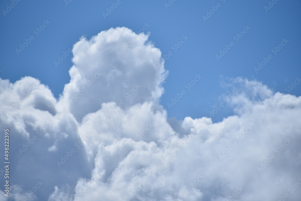Białe spiętrzone chmury na błękitnym niebie - obrazy, fototapety, plakaty 