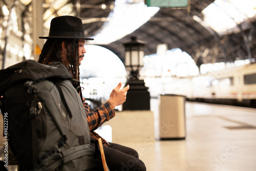 Handsome guy at railway station waiting for the train. Young man waiting to board a train.. photo