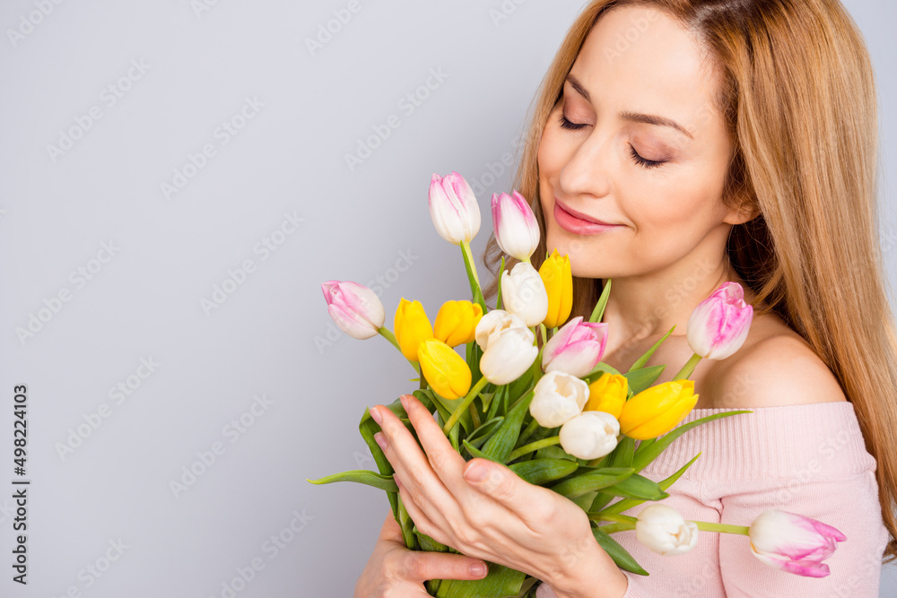 Cropped photo of charming lovely lady closed eyes smell fresh tulips isolated on grey color background